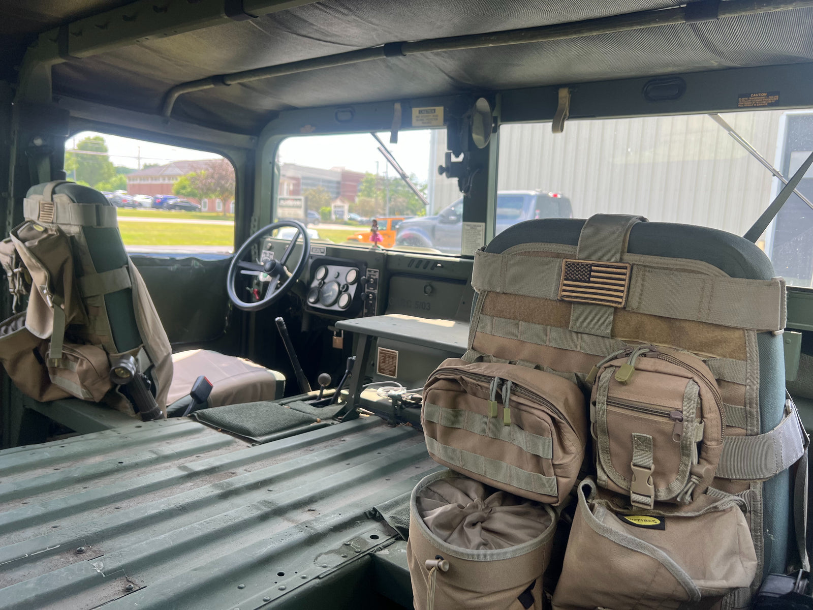 HMMWV cab interior looking across the seats, field packs stowed