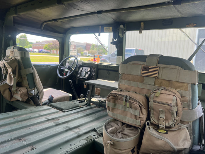 HMMWV cab interior looking across the seats, field packs stowed