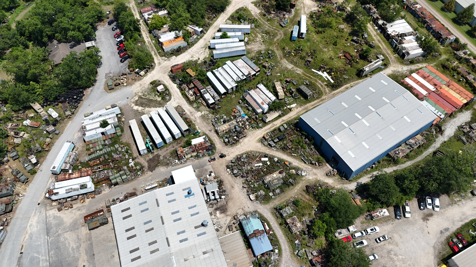 Aerial view of the SECO yard: warehouses, rows of tactical trucks and trailers, and open parts storage