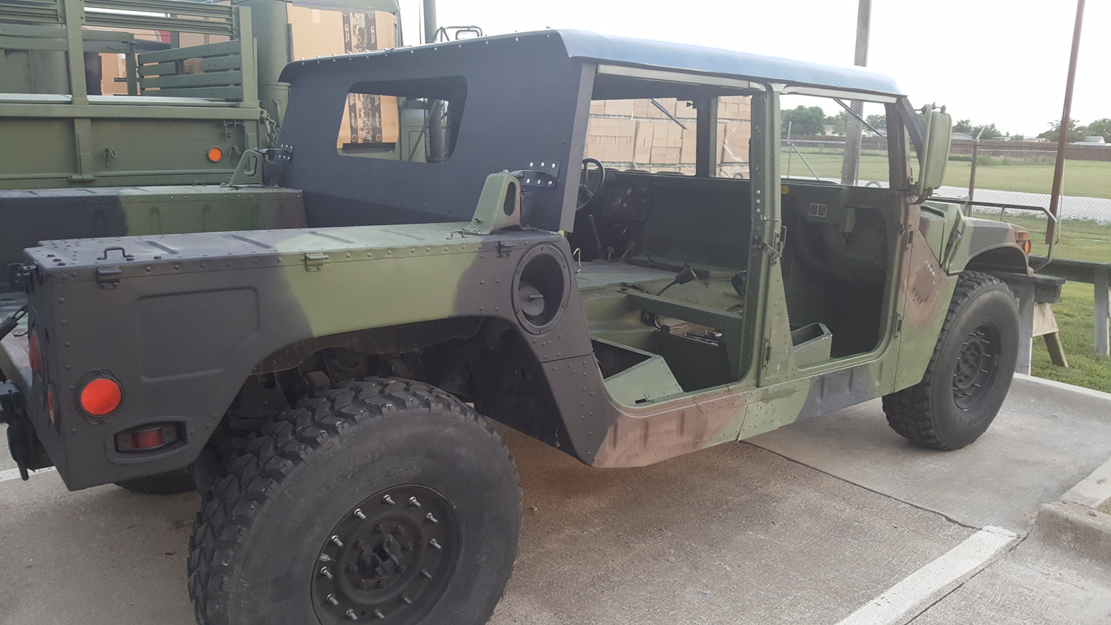 Camouflaged HMMWV with a new soft top and cargo curtain fitted, left side